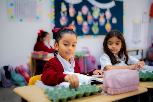 Pequeñas alumnas recibiendo clases con seguridad y prevención de enfermedades en Colegio APDE Entrevalles